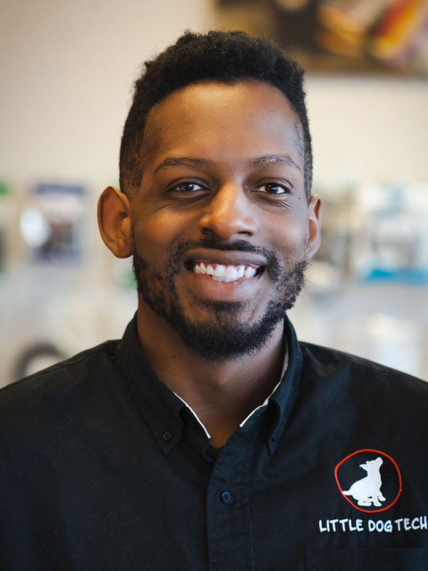 Close-up of a smiling man wearing a black shirt with the Little Dog Tech logo on the chest.